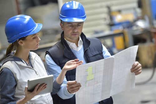 man and woman reviewing documents in warehouse